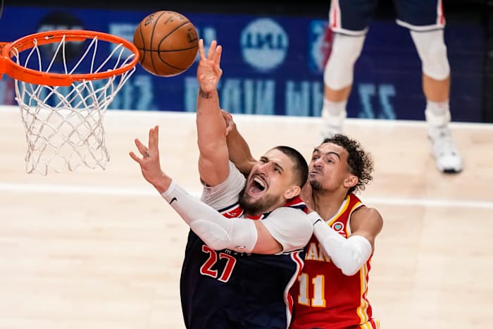 Washington Wizards center Alex Len (27) gets fouled from behind by Atlanta Hawks guard Trae Young (11) during the second half at State Farm Arena.